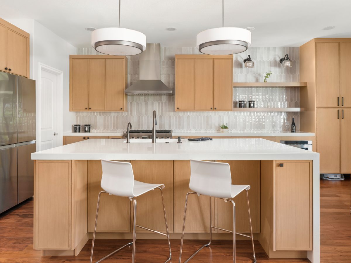 Contemporary kitchen with warm stained oak slim shaker cabinetry and off-white quartz island — Reveal Interior Design Las Vegas