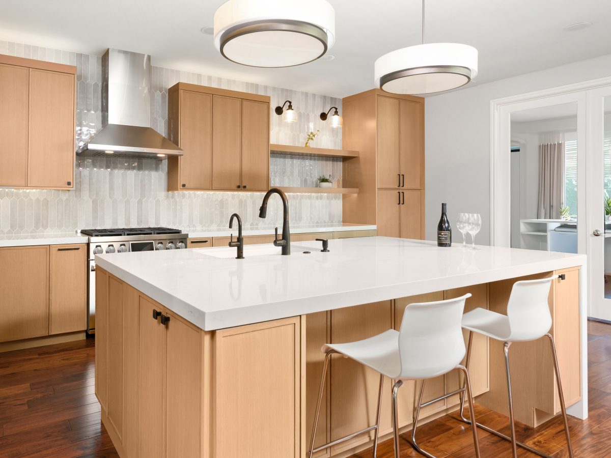 Contemporary kitchen with warm stained oak slim shaker cabinetry and quartz island — Reveal Interior Design Las Vegas