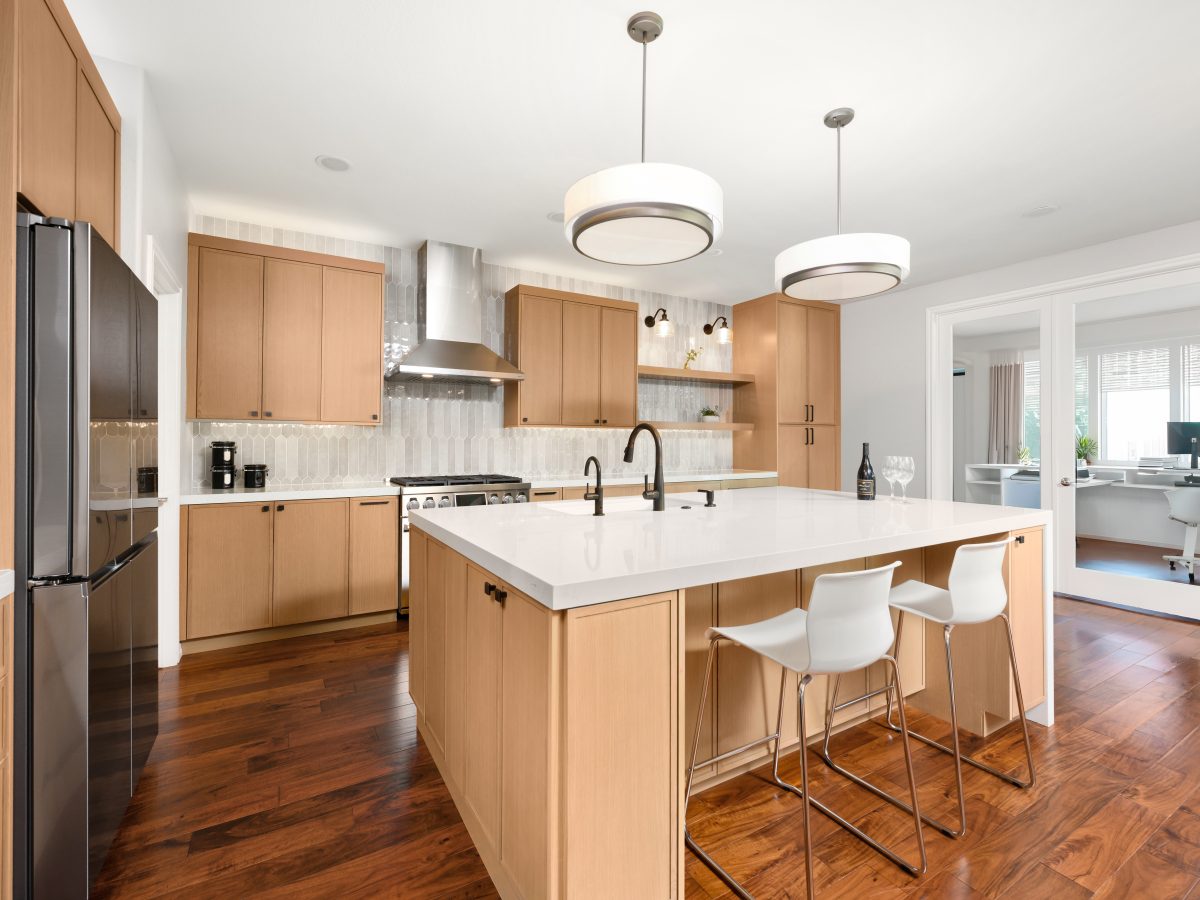 Warm oak shaker kitchen with quartz island, handmade-style picket backsplash tile, and dark bronze fixtures — Reveal Interior Design Las Vegas