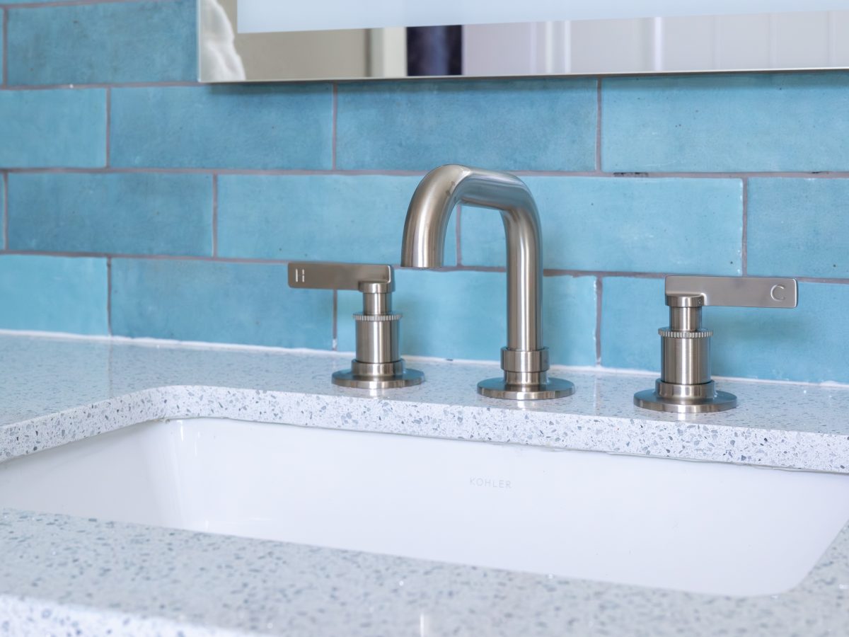 Primary bathroom vanity with white glitzy quartz countertop, brushed nickel fixtures, and handmade teal subway tile — Reveal Interior Design Las Vegas