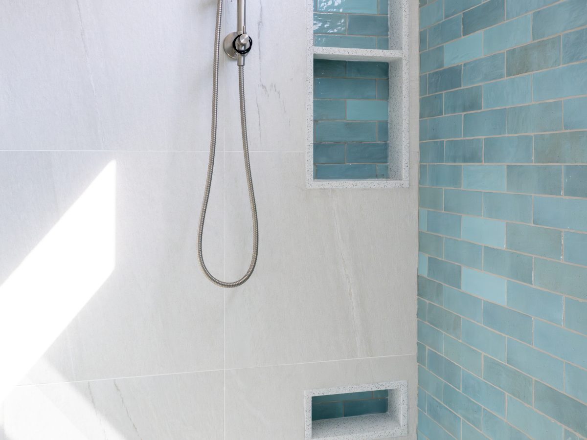 Spa primary shower with handmade teal subway tile, brushed nickel fixtures, and built-in niches — Reveal Interior Design Las Vegas