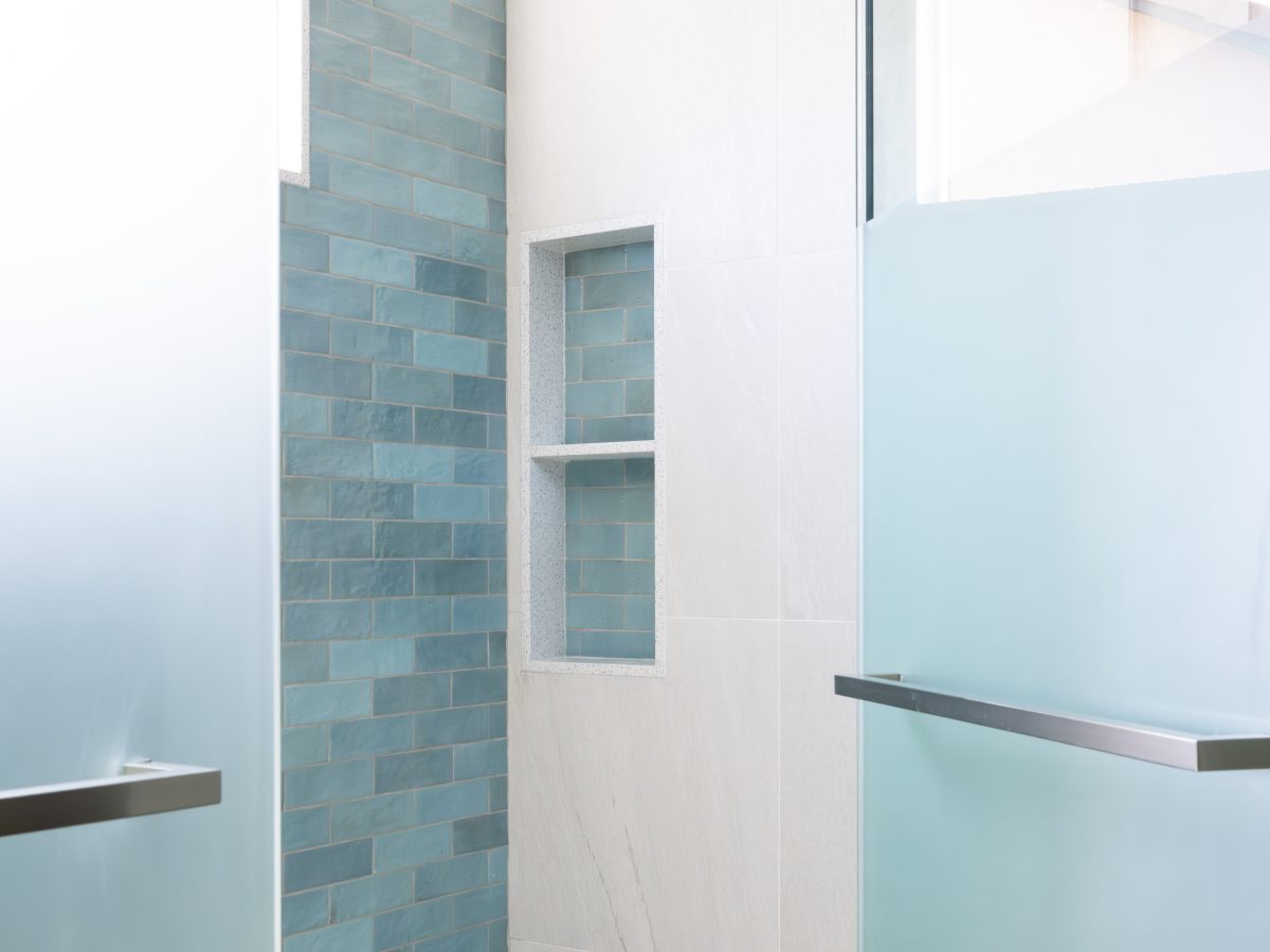 Spa primary shower with handmade teal subway tile, ceiling rain head, and custom privacy glass — Reveal Interior Design Las Vegas