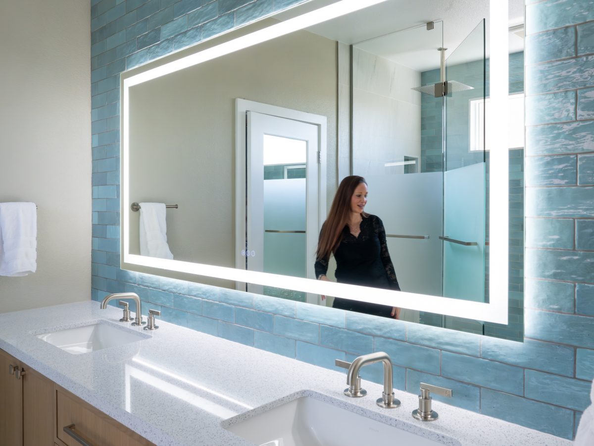 Spa primary bathroom with LED mirror, handmade teal subway tile, and white quartz double vanity — Reveal Interior Design Las Vegas