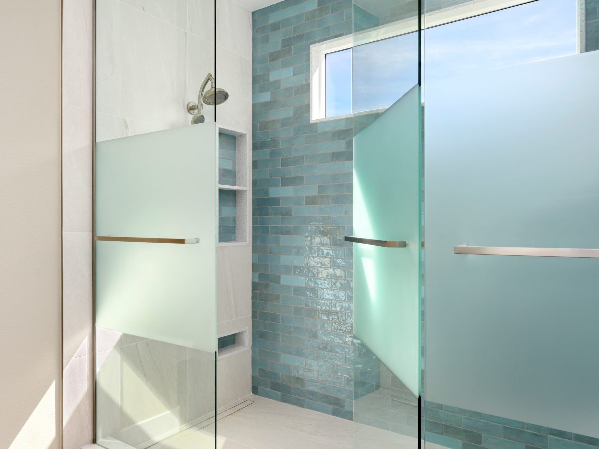 Spa-inspired two-person walk-in shower with handmade teal subway tile and custom privacy glass — Reveal Interior Design Las Vegas