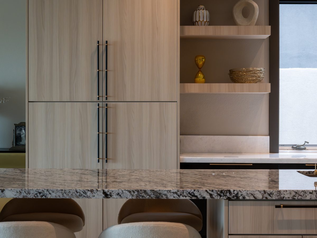 Luxury kitchen with granite island, white oak cabinetry, and gold pendant lighting — Reveal Interior Design Las Vegas