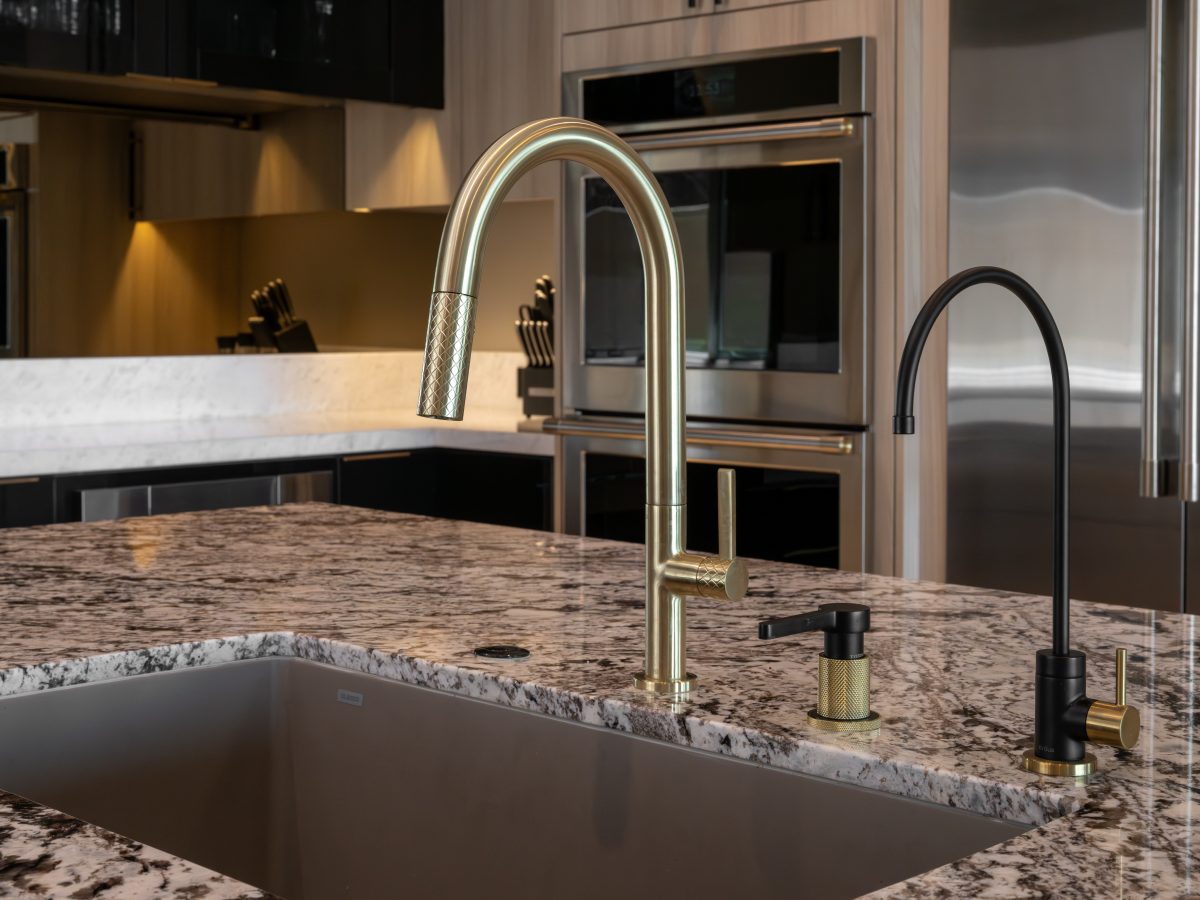 Luxury kitchen island with granite countertop, gold and black plumbing fixtures — Reveal Interior Design Las Vegas