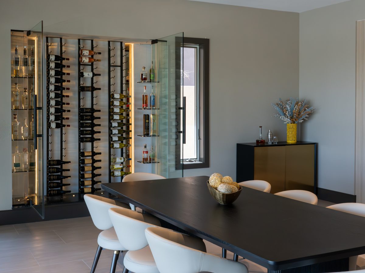 Custom wine niche with modern metal shelving, mirrored panels, and hidden LED lighting — Reveal Interior Design Las Vegas