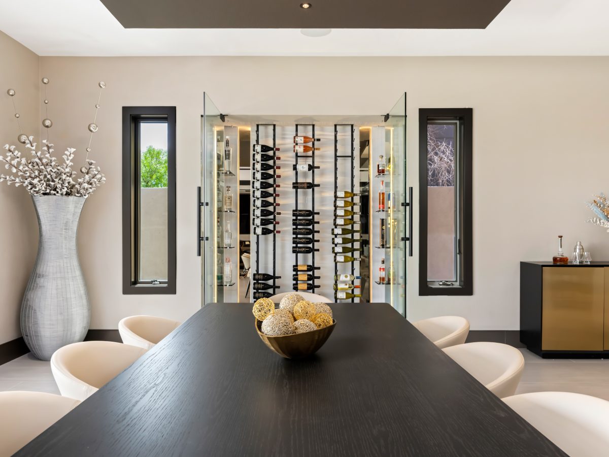 Custom wine niche with modern metal shelving, mirrored panels, and hidden LED lighting — Reveal Interior Design Las Vegas