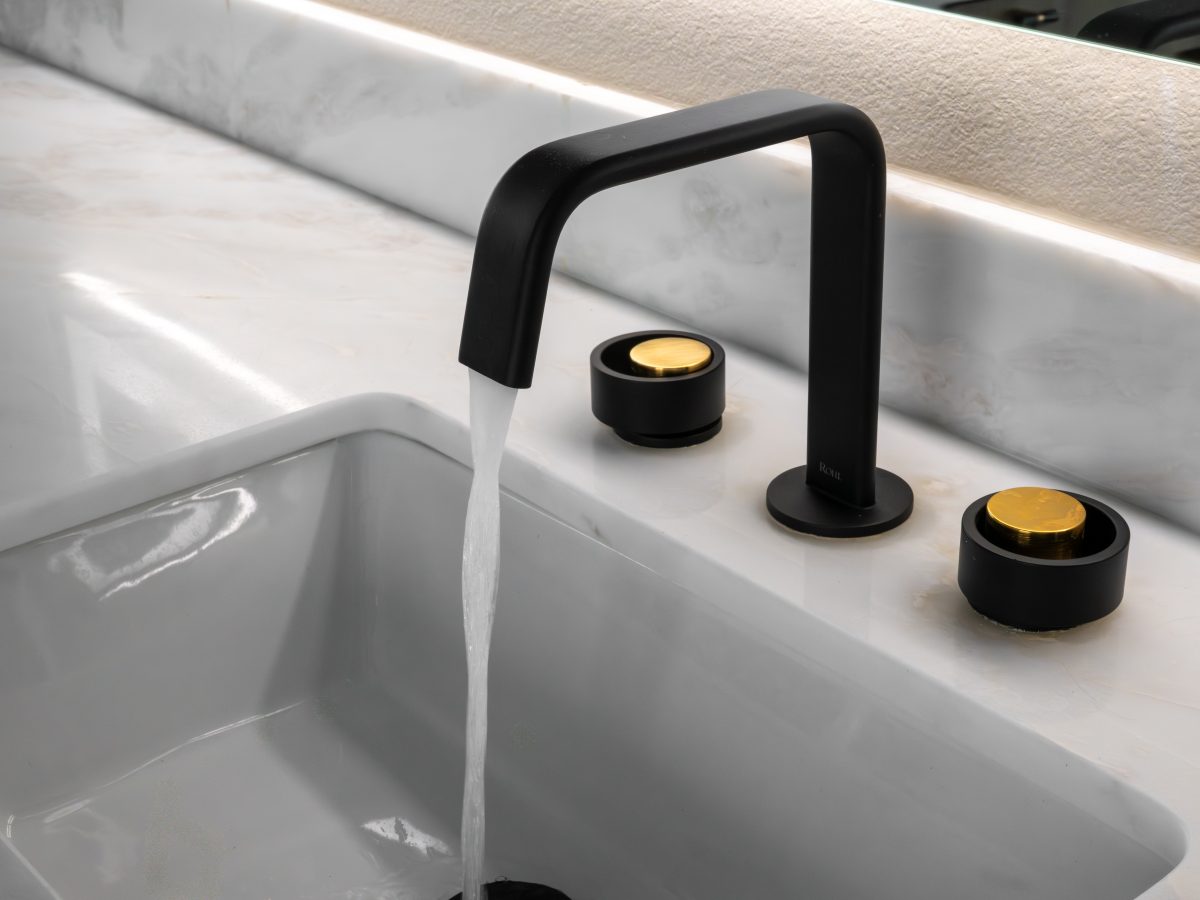 Primary bathroom black matte faucet with gold knob handles on white stone countertop — Reveal Interior Design Las Vegas