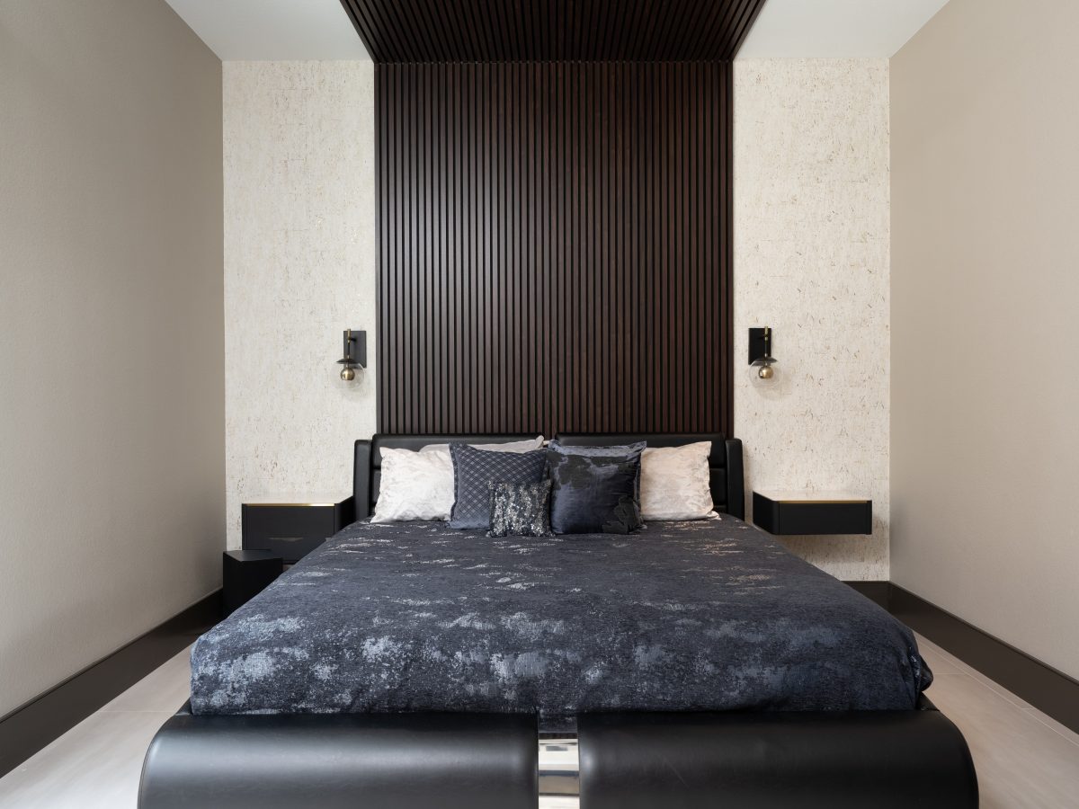Guest bedroom with dramatic floor-to-ceiling wood panel headboard and cork-look wallcovering — Reveal Interior Design Las Vegas