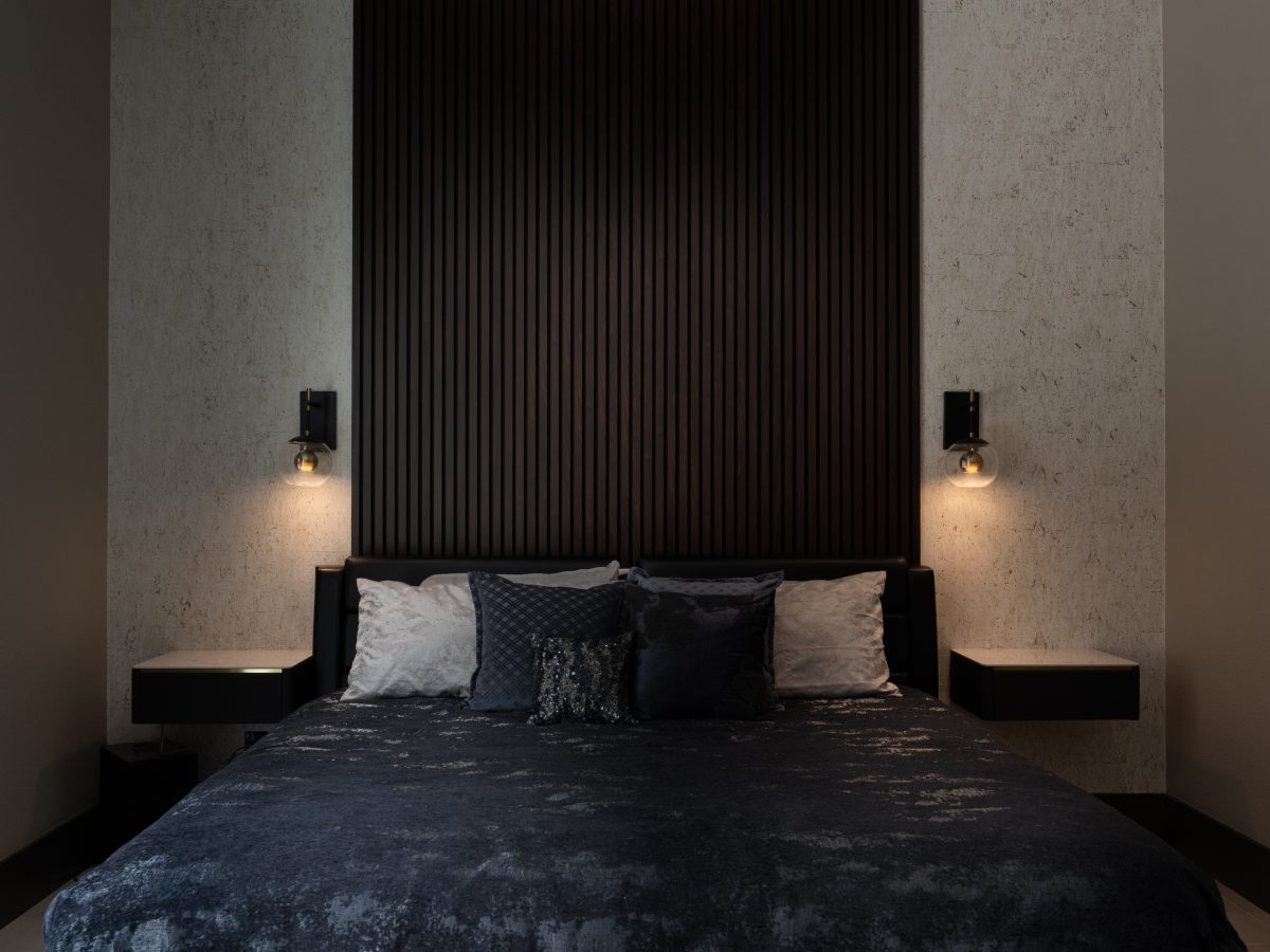 Guest bedroom with dramatic floor-to-ceiling wood panel headboard and cork-look wallpaper — Reveal Interior Design Las Vegas