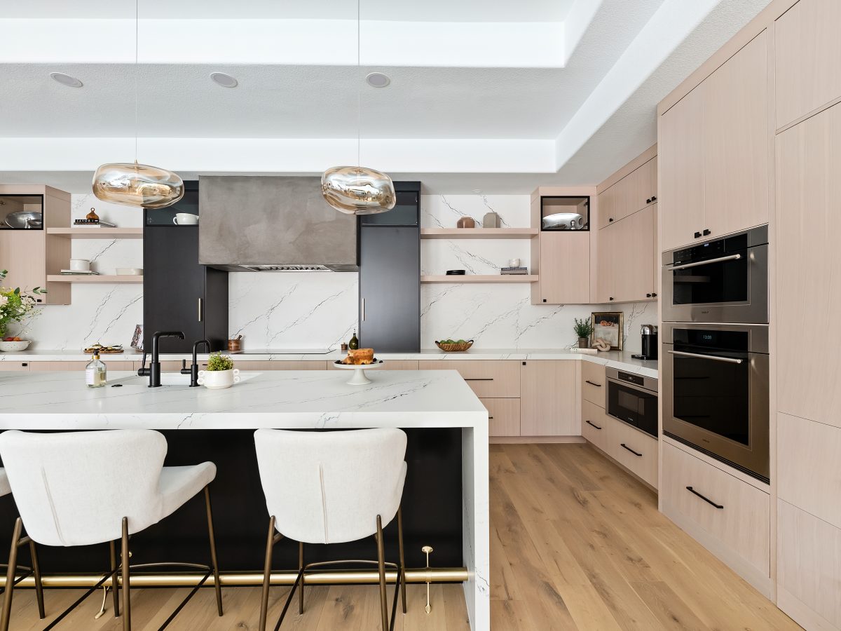 Luxury kitchen with whitewashed oak cabinetry, black quartz countertops, and matte black accents — Reveal Interior Design Las Vegas