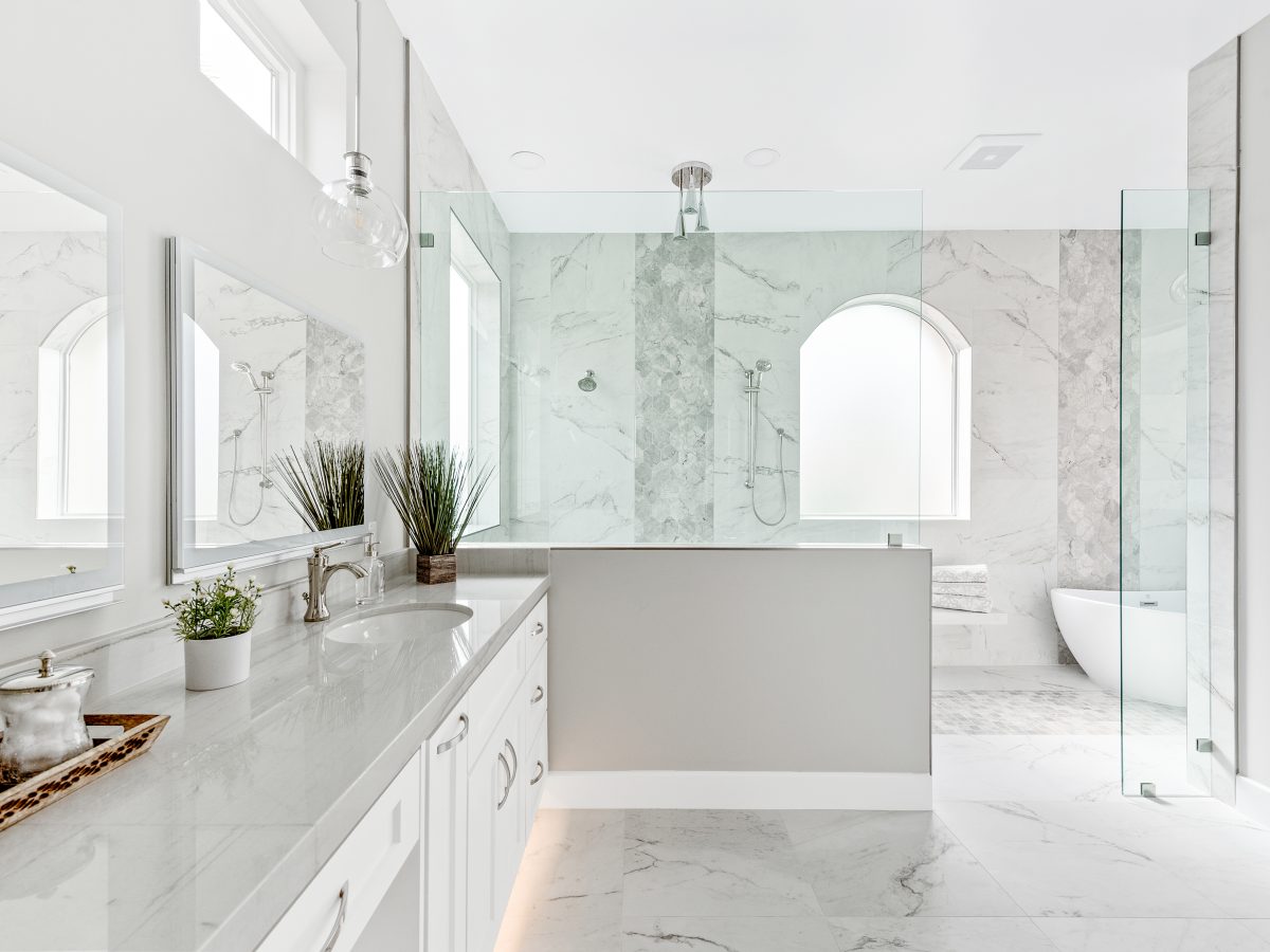 Transitional primary bathroom wet room with Taj Mahal quartzite vanity and marble-look porcelain tile — Reveal Interior Design Las Vegas
