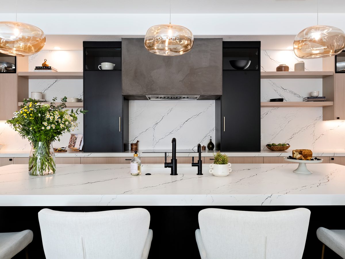 Contemporary kitchen with black-veined white quartz island, whitewashed oak cabinetry, and matte black accents — Reveal Interior Design Las Vegas