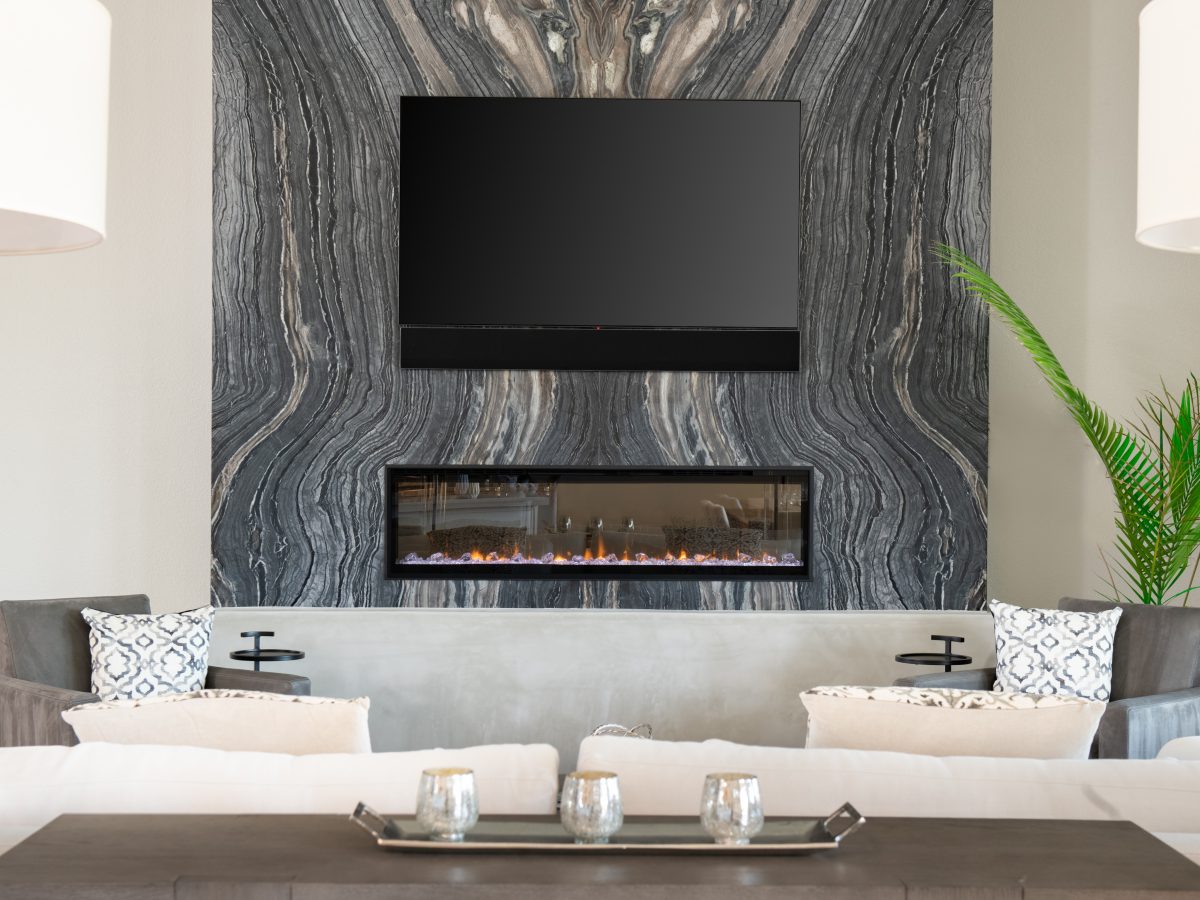 Living room with bookmatched leathered quartzite fireplace wall and linear electric fireplace — Reveal Interior Design Las Vegas