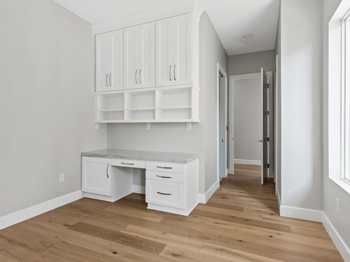 Built-in home office with white shaker cabinetry, open shelving, and stone countertops — Reveal Interior Design Las Vegas
