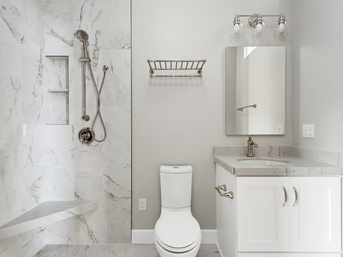 Transitional guest bathroom with marble-look porcelain tile and Taj Mahal quartzite vanity — Reveal Interior Design Las Vegas