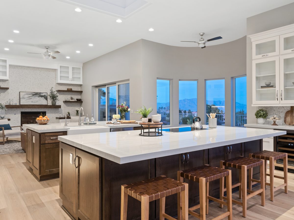 Transitional kitchen with Taj Mahal quartzite islands and dark stained maple cabinetry — Reveal Interior Design Las Vegas