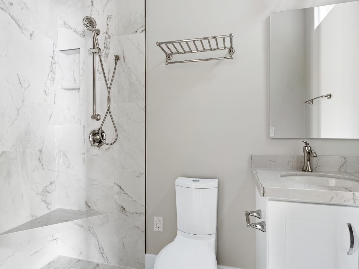 Transitional guest bathroom with marble-look porcelain tile shower and Taj Mahal quartzite vanity — Reveal Interior Design Las Vegas