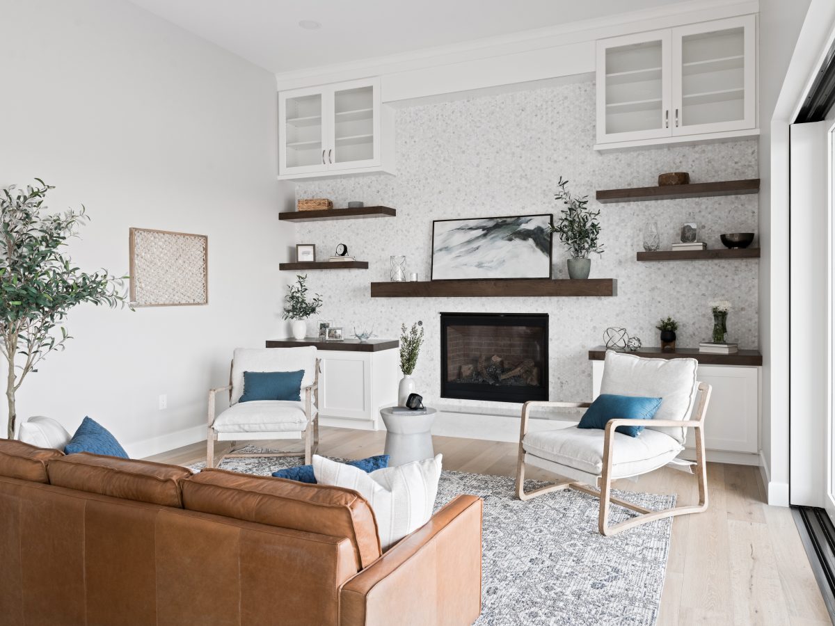 Family room with geometric marble tile fireplace wall, dark stained floating shelves and mantel — Reveal Interior Design Las Vegas