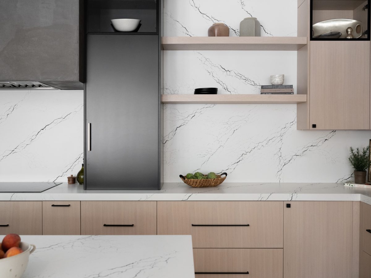 Modern kitchen with white quartz countertops and backsplash, whitewashed oak cabinetry, matte black accents — Reveal Interior Design Las Vegas