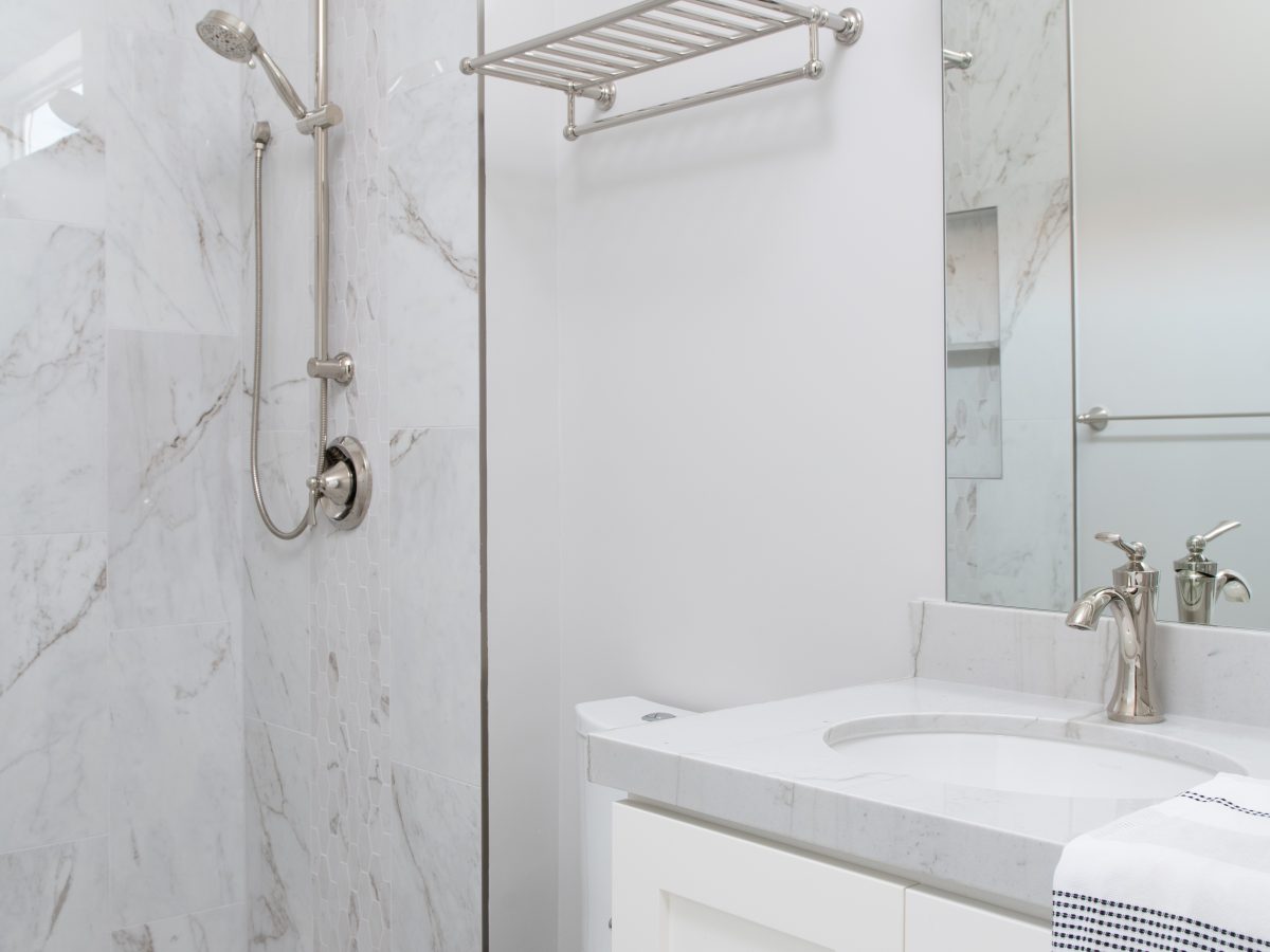 Transitional guest bathroom with stone-look porcelain tile and Taj Mahal quartzite vanity — Reveal Interior Design Las Vegas