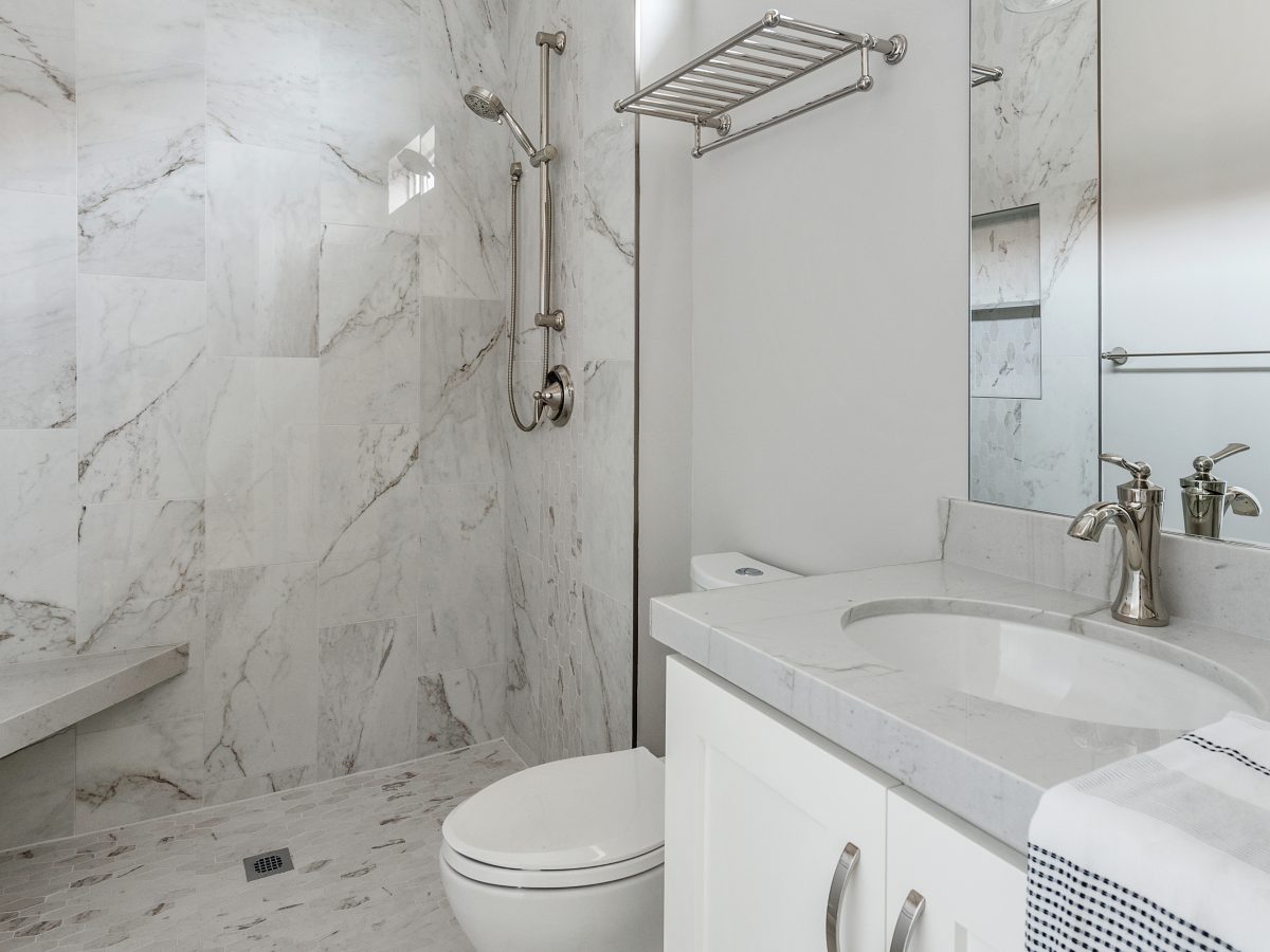 Transitional guest bathroom with stone-look porcelain tile and Taj Mahal quartzite vanity — Reveal Interior Design Las Vegas