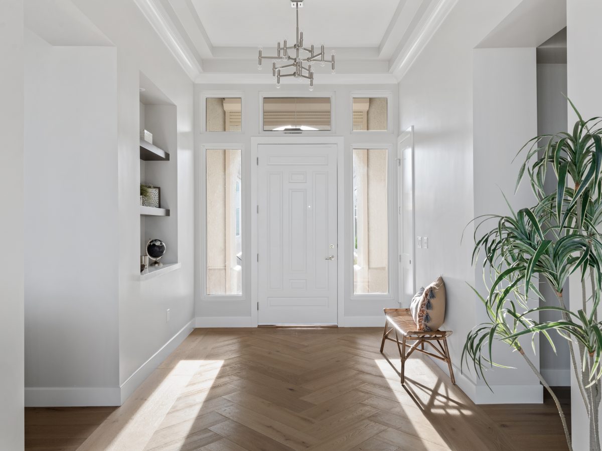 Elegant entryway with herringbone engineered hardwood and floating niche shelves — Reveal Interior Design Las Vegas
