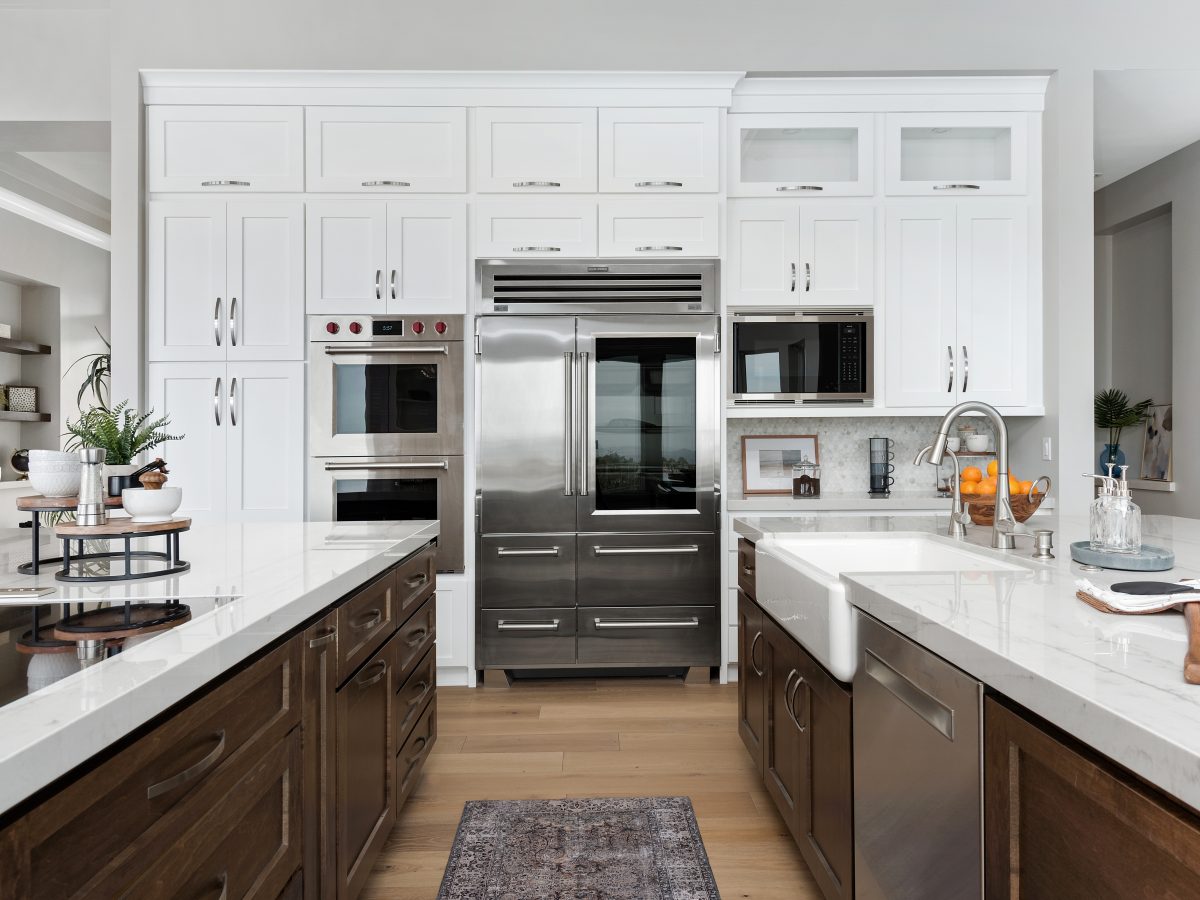 Transitional kitchen with Taj Mahal quartzite countertops and dark stained maple cabinetry — Reveal Interior Design Las Vegas