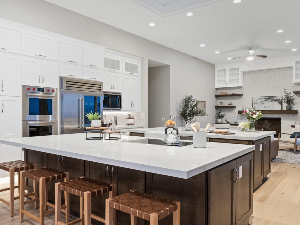 Transitional kitchen with Taj Mahal quartzite islands, dark stained maple and off-white shaker cabinetry — Reveal Interior Design Las Vegas