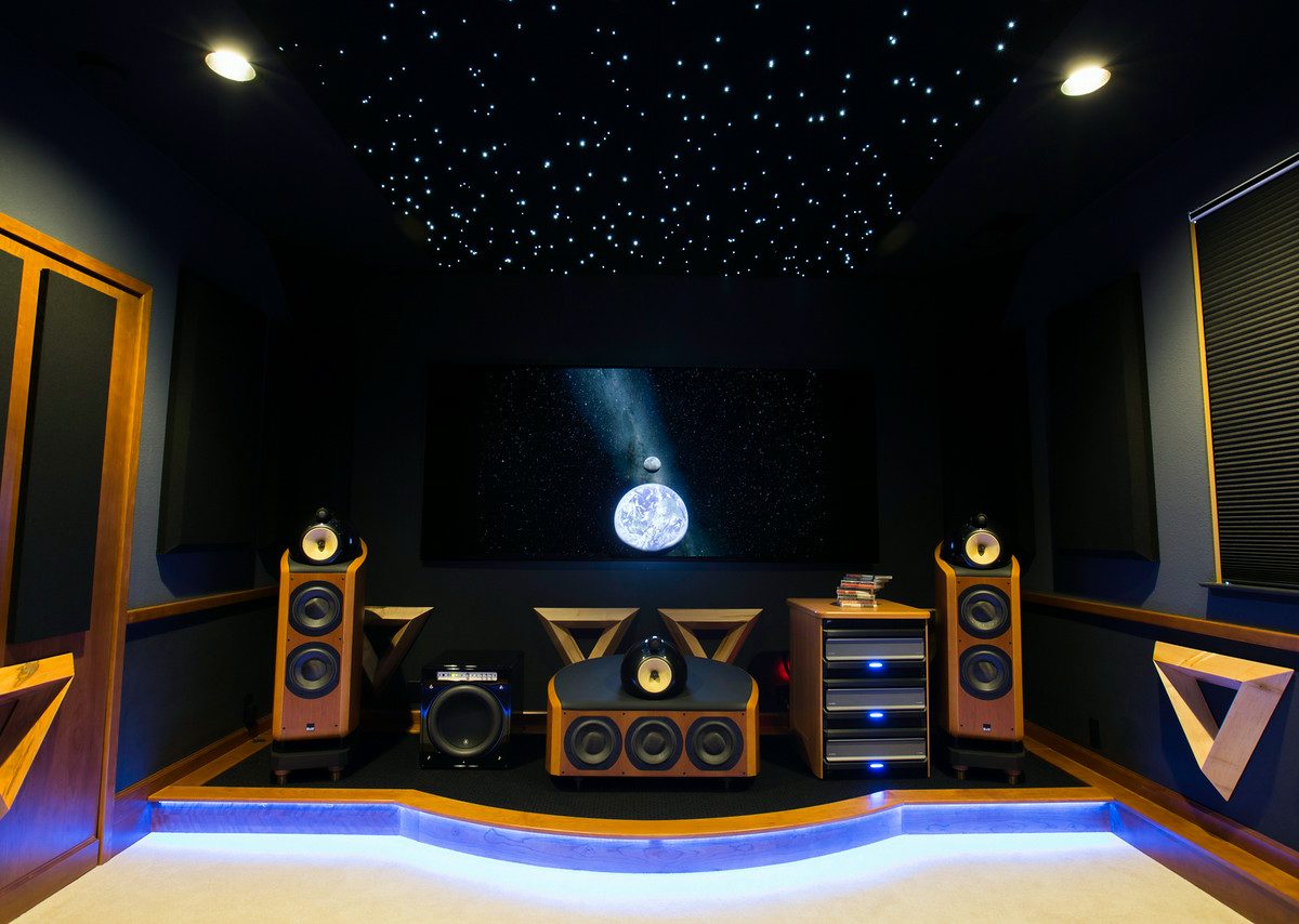 Home theater with fiber optic star ceiling, maple acoustic panels, and raised speaker stage — Reveal Interior Design Las Vegas