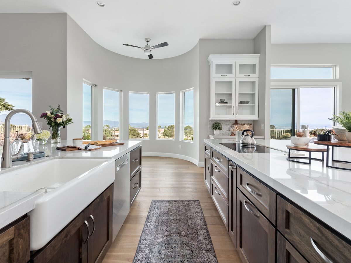 Transitional kitchen with Taj Mahal quartzite countertops and dark stained maple cabinetry — Reveal Interior Design Las Vegas