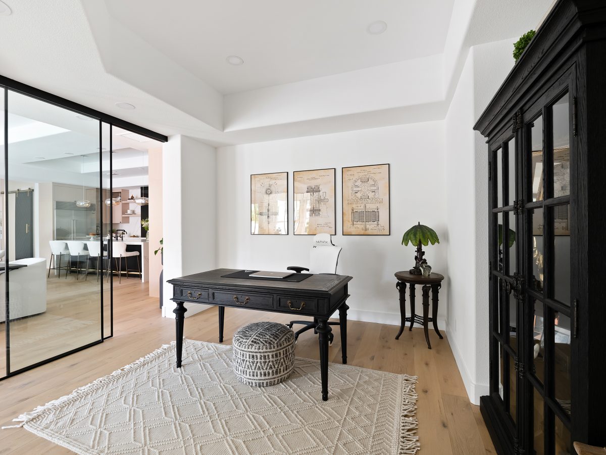 Home office with black steel-framed glass wall and oak engineered flooring — Reveal Interior Design Las Vegas