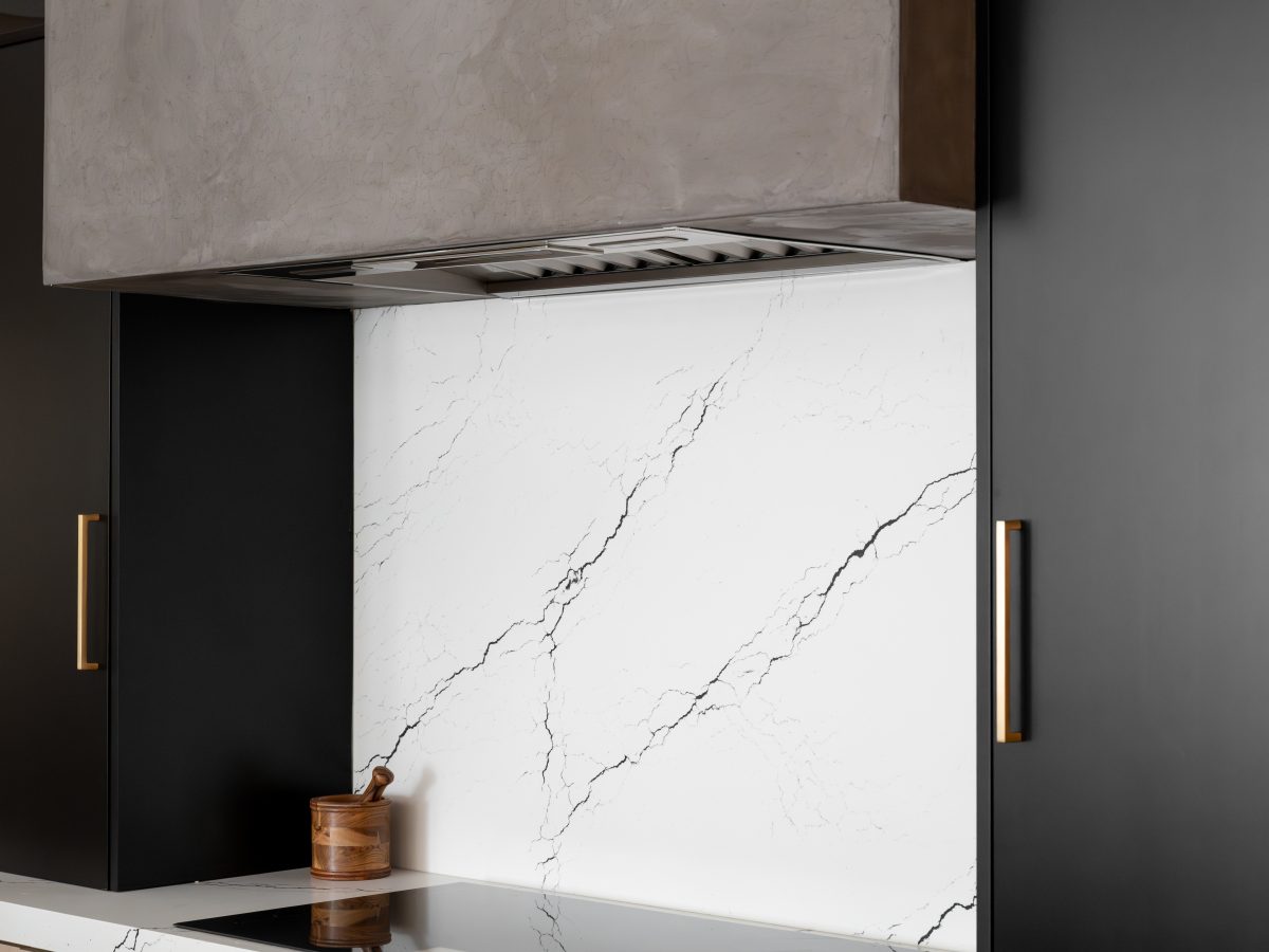 Modern kitchen with warm white-washed oak cabinetry, matte black accents, and black-veined white quartz — Reveal Interior Design Las Vegas