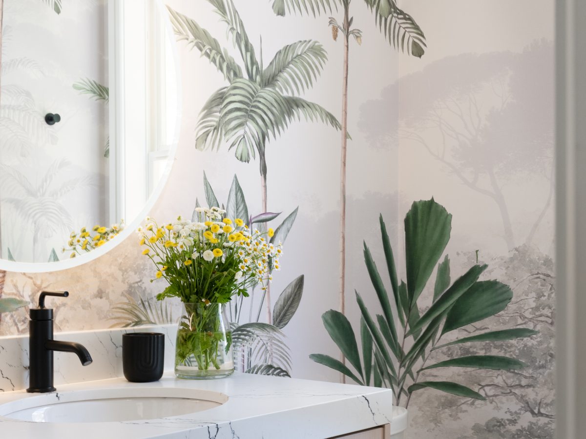 Powder bath with tropical botanical mural wallcovering and light wood vanity — Reveal Interior Design Las Vegas