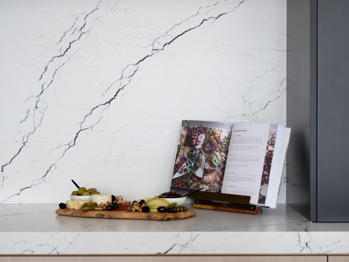 Kitchen with black-veined white quartz countertops and backsplash, white-washed oak cabinetry — Reveal Interior Design Las Vegas