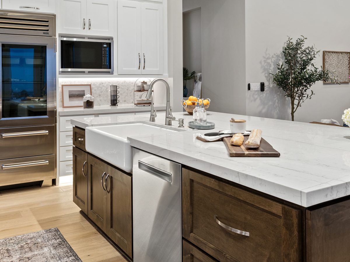 Transitional kitchen with Taj Mahal quartzite island, dark stained maple and off-white cabinetry — Reveal Interior Design Las Vegas