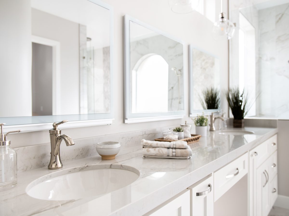 Transitional primary bathroom with Taj Mahal quartzite double vanity and polished nickel fixtures — Reveal Interior Design Las Vegas