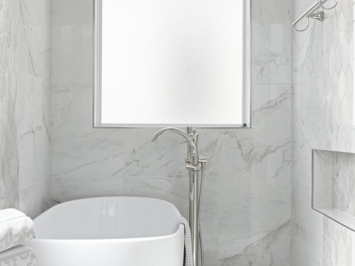 Transitional primary bathroom wet room with freestanding soaking tub and marble-look porcelain tile — Reveal Interior Design Las Vegas