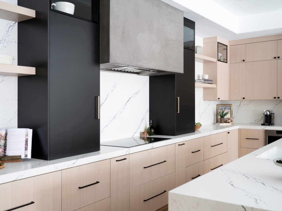 Modern kitchen with whitewashed oak cabinetry, matte black accents, and black-veined white quartz countertops — Reveal Interior Design Las Vegas