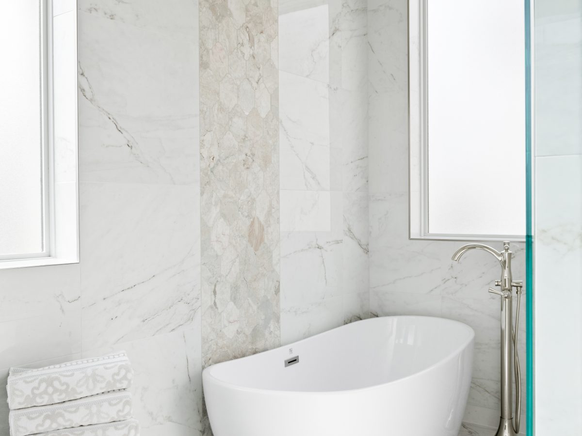 Transitional primary bathroom wet room with freestanding soaking tub and Taj Mahal quartzite accent — Reveal Interior Design Las Vegas