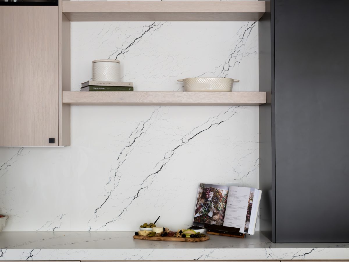 Kitchen floating shelves with white-washed oak cabinetry, matte black accents, and black-veined white quartz backsplash — Reveal Interior Design Las Vegas