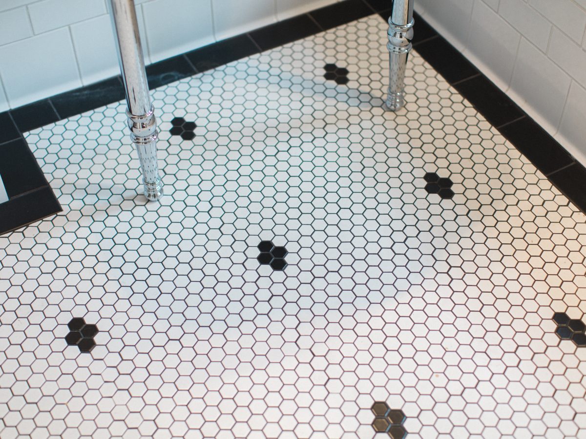 Bathroom hex mosaic floor with black accent tiles and chrome pedestal sink — Reveal Interior Design Las Vegas