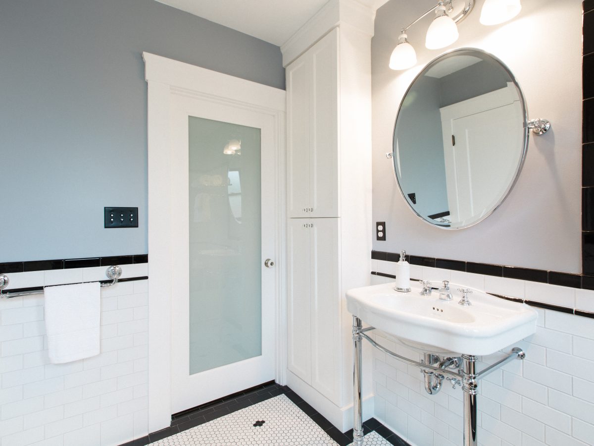 Historic black-and-white bathroom with hex mosaic floor and freestanding chrome sink — Reveal Interior Design Las Vegas